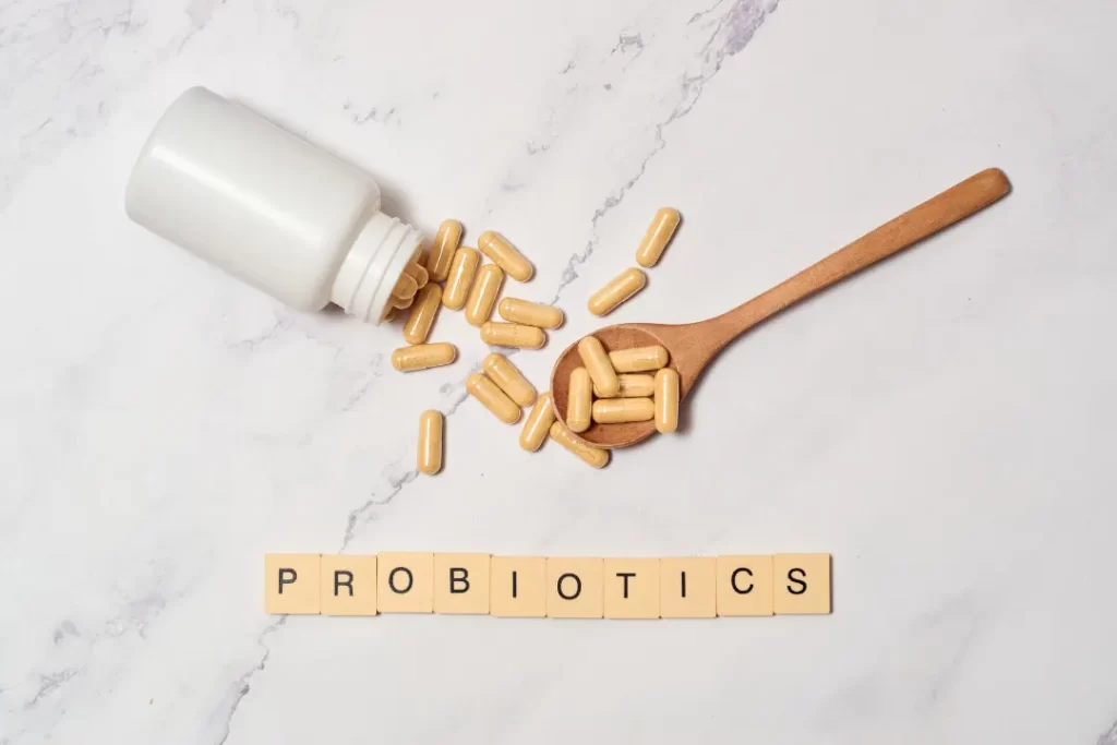Probiotics supplements bottle with a wooden spoon.