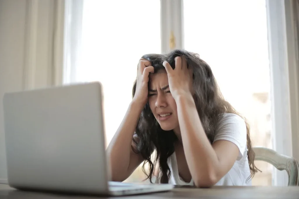 A young lady being stressed while working on the laptop.