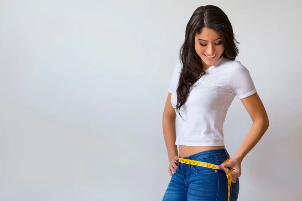 A young girl measuring her waist. 