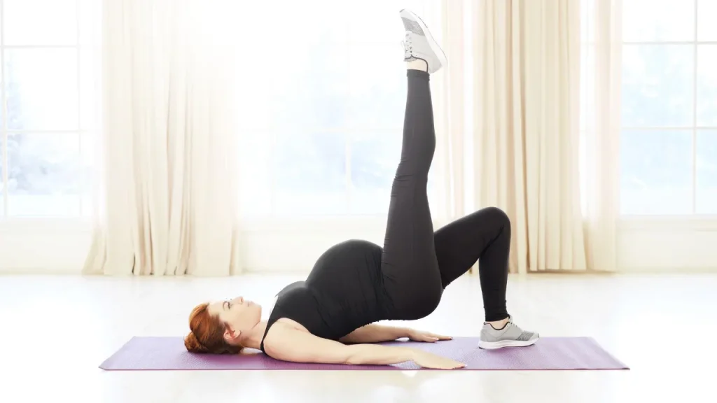 Pregnant lady is doing exercise. 