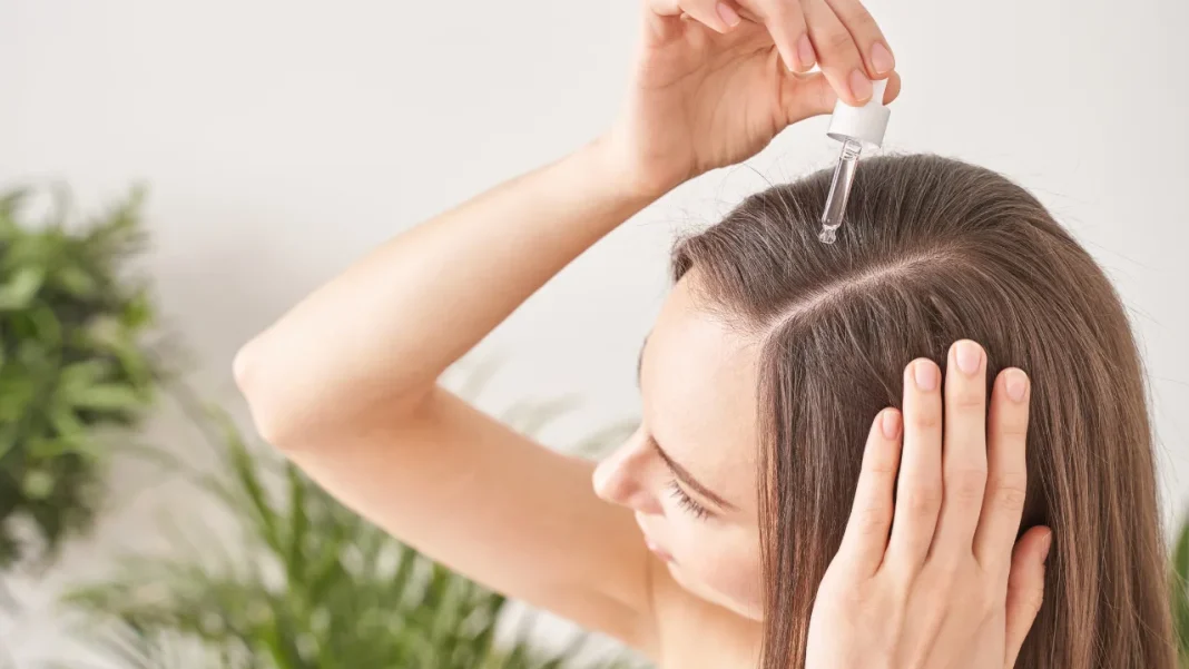 Girl applying moringa oil in her scalp